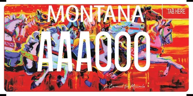 A multi-colored license plate with white text and an illustrated carousel horses across plate. Bottom says A Carousel for Missoula in cursive.