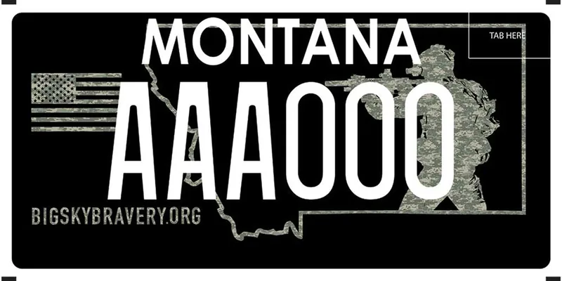 A black license plate with white text. A camo grayscale flag is on left and a soldier pointing gun on right. Bottom say Bigskybravery.org.