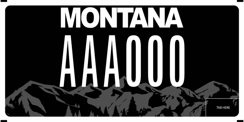 A black and grayscale license plate with white text. Mountains in background.