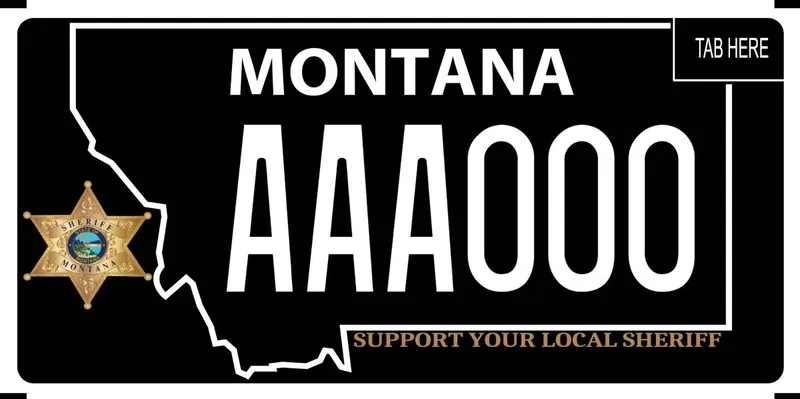 A black license plate with white text. Sheriff badge is on left side that says Sheriff Montana. Bottom says Support Your Local Sheriff in gold.