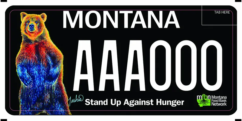 A black license plate with white text. A standing multi colored grizzly bear on left side. Colors are blue, red, orange. Bottom says Stand Up Against Hunger. Montana Food Bank Network logo in bottom right corner.