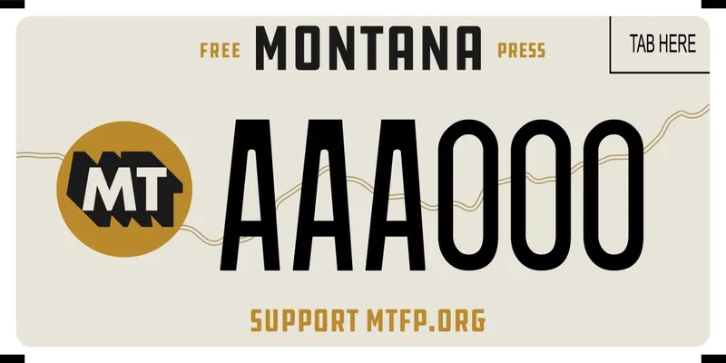 A cream colored license plate with black and burnt orange text. Top says Free Montana Press and bottom says Support MTFP dot org.
