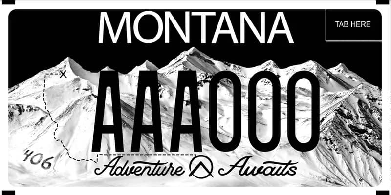 A black and white license plate with black text. A snowy mountain range. Bottom say Adventure Awaits in cursive.