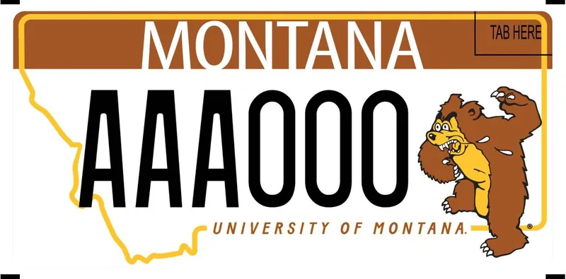 A white license plate with white, black, and brown text. A outline of the state in yellow and brown banner at top. An illustration of a bear raising a paw and growling on right. Bottom text in brown says University of Montana.